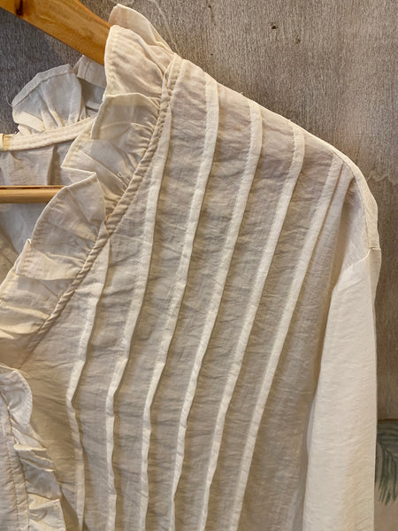 Blusa nervuras e folhos creme