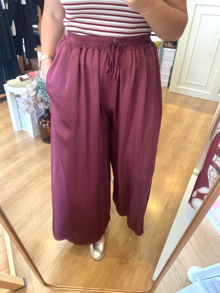 Calças pantalonas acetinadas lisas bordeaux